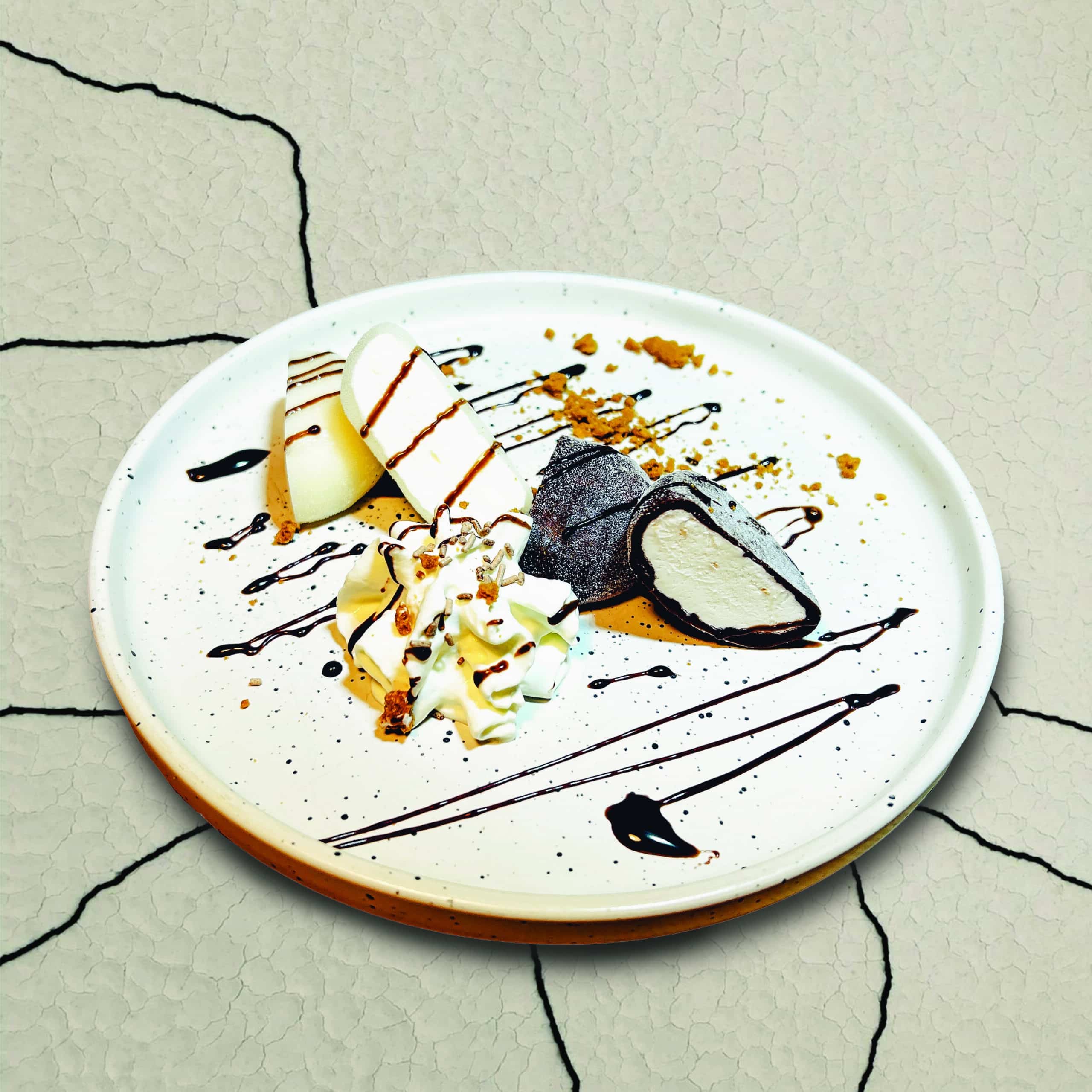 Des mochis, petites boules de pâte de riz gluant, fourrées de crème et accompagnées de chantilly et sauce au chocolat